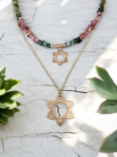 Tourmaline Flower Necklace Set in Silver 14K Gold Plated displayed on a distressed white background with green plants