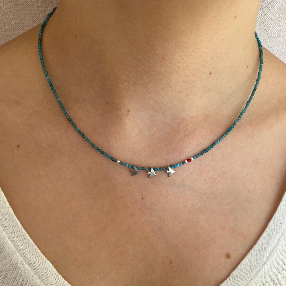 Trio Birdie Minimal Silver Necklace featuring delicate silver bird pendants on a thin turquoise chain worn around the neck.