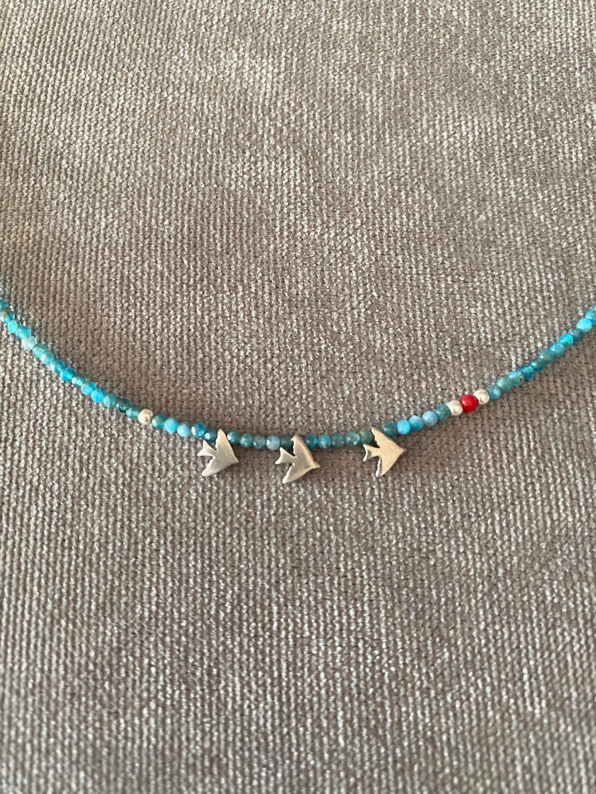 Trio Birdie Minimal Silver Necklace with blue and red beads on a grey background