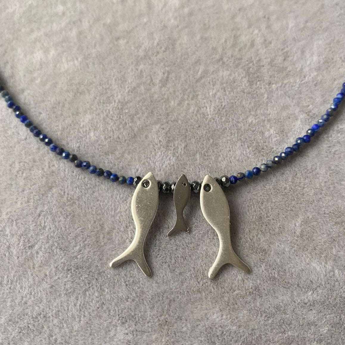 Trio Fish Family Lapis Necklace featuring three silver fish pendants with blue beaded strand