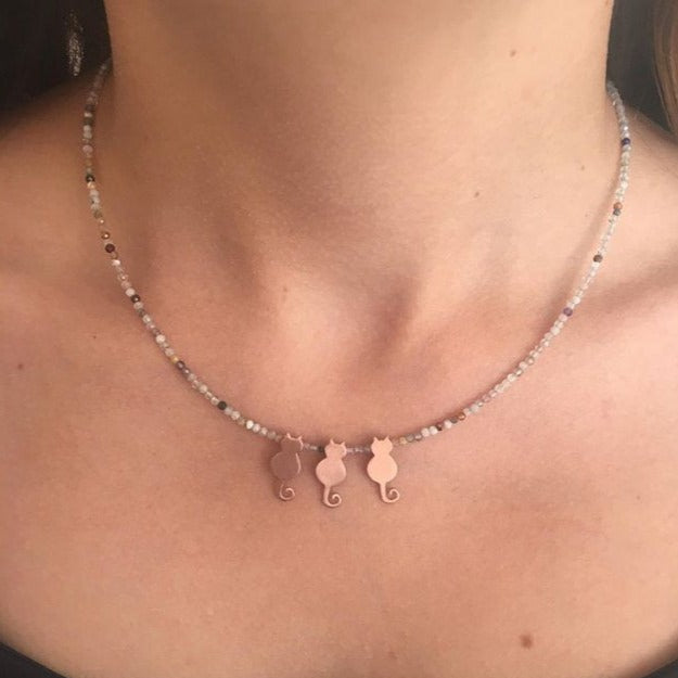 Trio Mini Cat Silver Necklace displayed on a woman's neck.